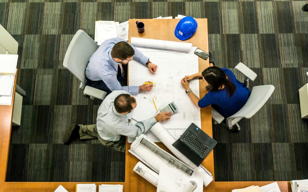 Top view of a team working on construction management plans in an office setting.