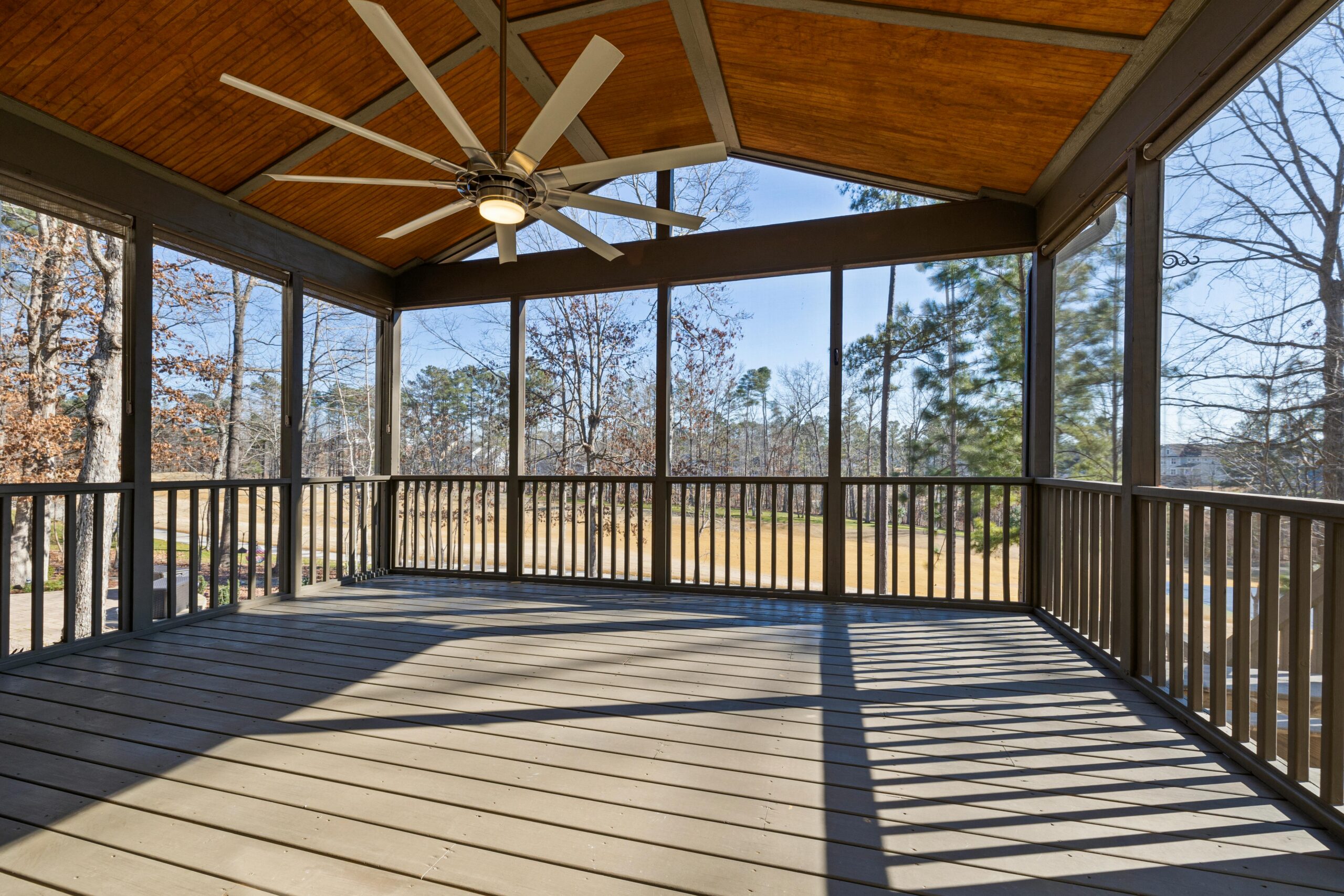 Deck Restoration in Ohio.  A well-lit patio with a ceiling fan offering a view of nature during the day.