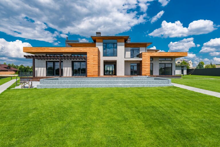 Exterior of contemporary building with green grass in yard in daytime under blue sky